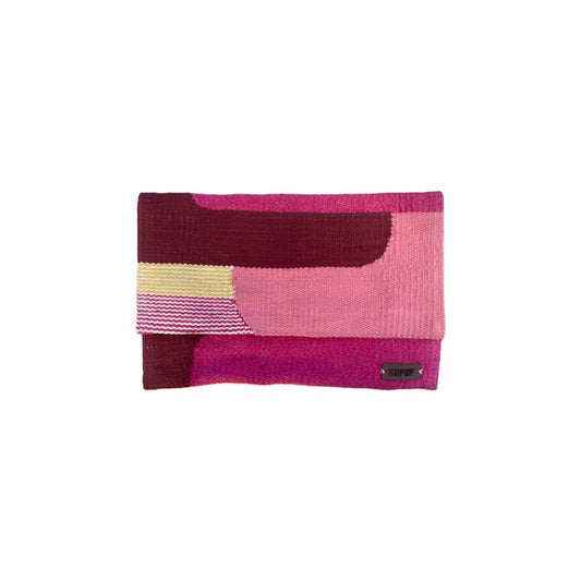 A colorful, clutch featuring shades of pink, maroon, and yellow, with a textured surface and a small black label at the bottom right.