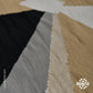 The image features a close-up of a textured textile with a geometric pattern. The design includes various colors such as black, gray, beige, and white, arranged in angular shapes. The fabric appears to have a woven quality, showcasing different textures and tones. The bottom right corner displays a logo for "KilimFit."