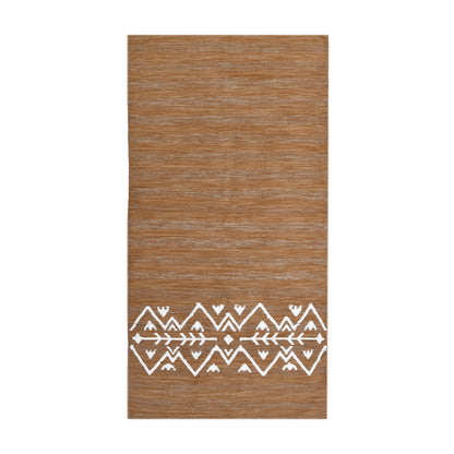 A long, narrow rug in a light brownish-tan color is shown against a white background. The rug has a slightly textured, woven appearance with subtle variations in shade. Near the bottom, a band of white geometric designs is woven into the rug. The pattern consists of symmetrical rows of white triangles, zigzags, and stylized arrow shapes, creating a visually appealing and slightly bohemian aesthetic. The overall style of the rug is simple yet elegant with a size of 1 x 2 meters.