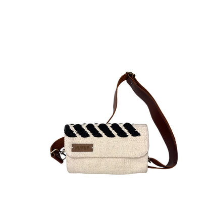 "A cream-colored woven bag with a black striped design on the front, featuring a brown leather strap. The bag is displayed against a white background, showcasing its modern style and texture."