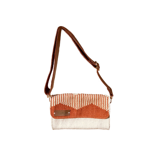 A stylish woven handbag featuring a striped design in orange and cream, with a brown flap and a metal label that reads "KUFUF." The bag is displayed against a plain white background, highlighting its unique craftsmanship and color contrast.